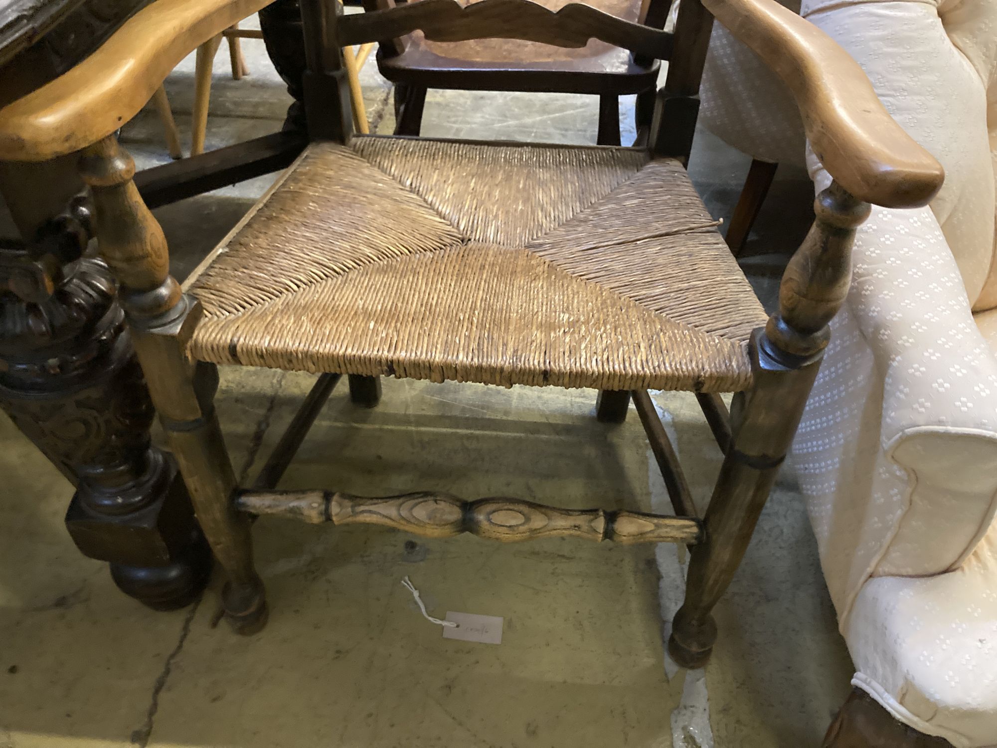 A 19th century ash and beech ladderback elbow chair and a spindle back elbow chair (2)